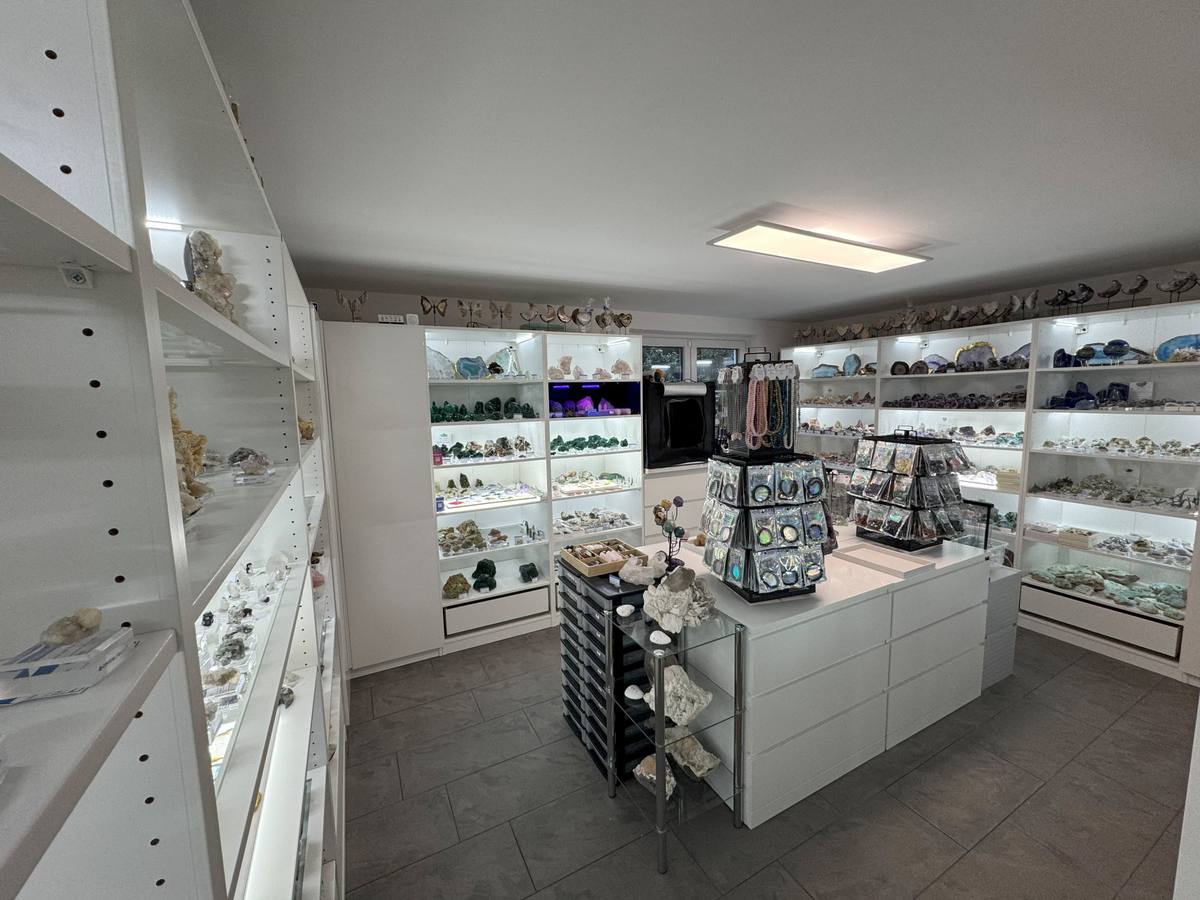 Verkaufsraum von Crystal Paradise in Feldkirchen mit beleuchteten Regalen voller Edelsteine, Mineralien und Kristalle